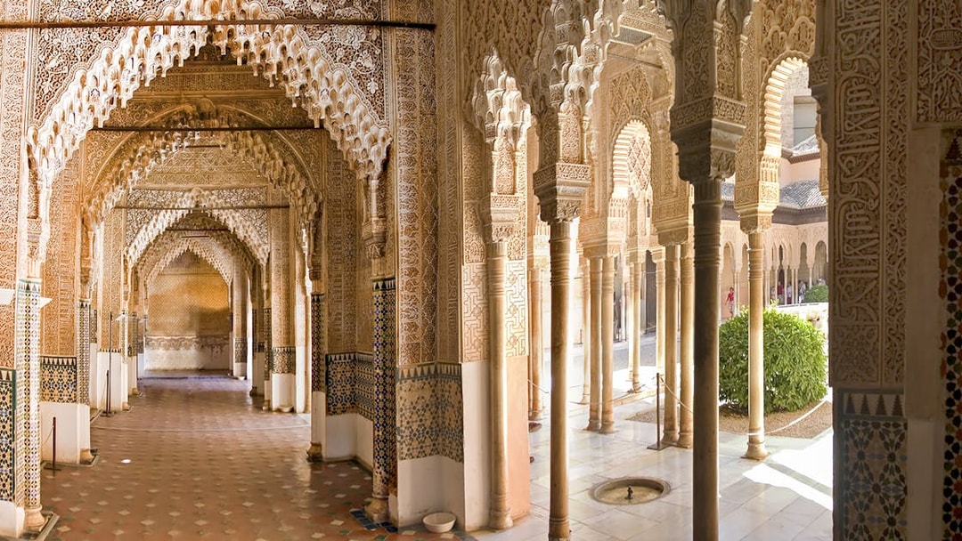 Alhambra's intricate Moorish arches and columns on a guided tour in Granada, Spain.