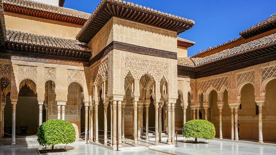 Alhambra's Nasrid Palaces courtyard with intricate arches and columns, Granada, Spain.