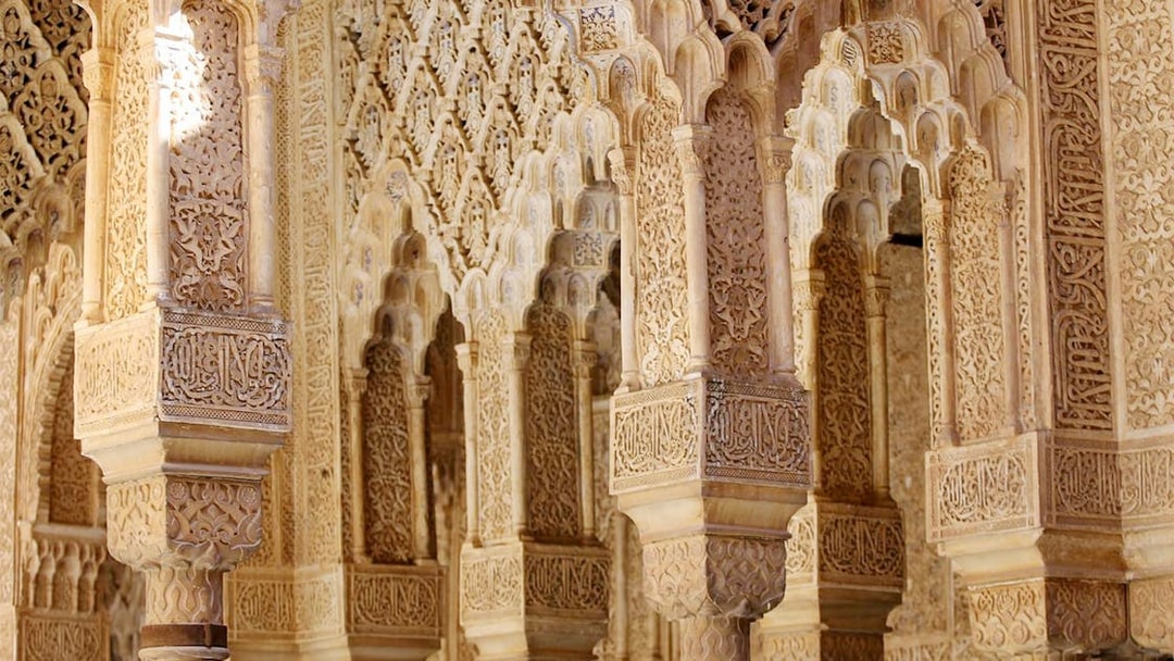 Intricate Moorish arches in the Nasrid Palaces, Alhambra, Granada.