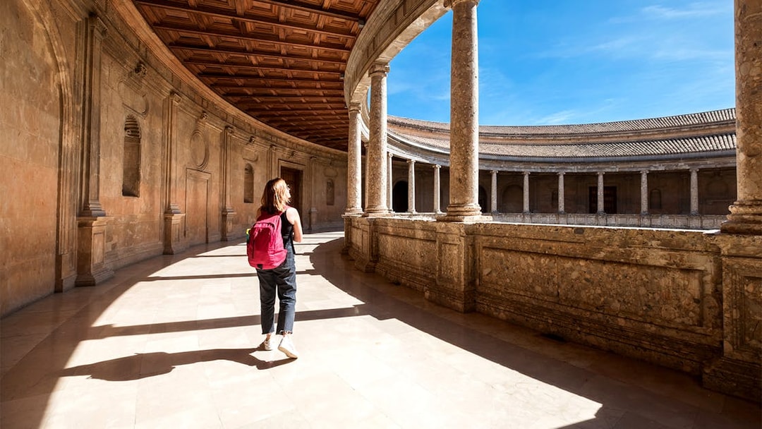 Tourist walking through the Alhambra palace courtyard in Granada, Spain.