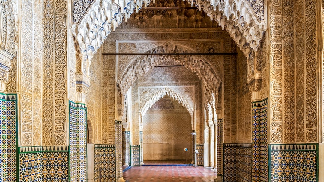 Alhambra intricate arches and tilework on guided tour in Granada, Spain.