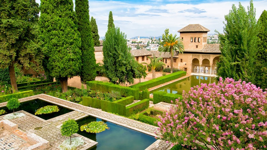 Alhambra's gardens with lush greenery and reflecting pools, Andalusia, Spain.