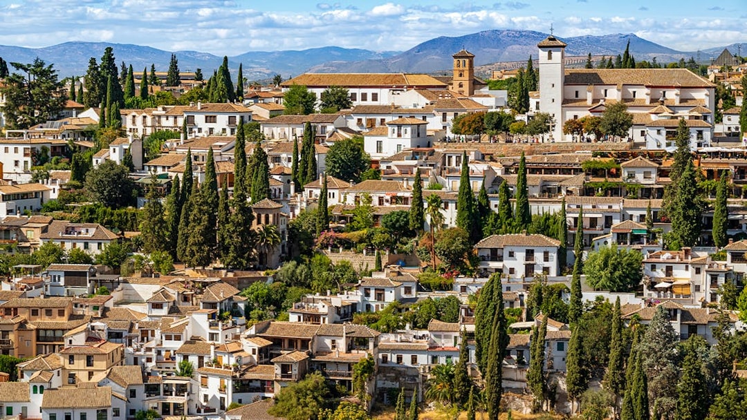 Granada's Albaicín district with whitewashed buildings and cypress trees, view from Alhambra.