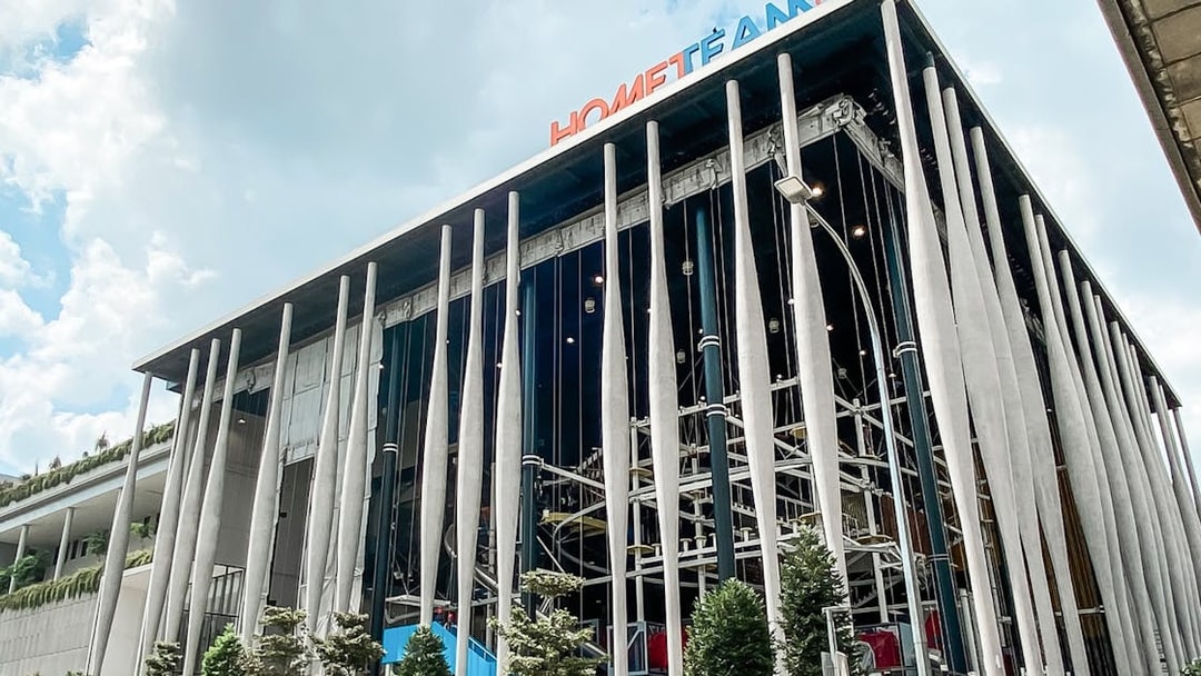 Modern building facade of Adventure HQ with vertical columns and greenery.