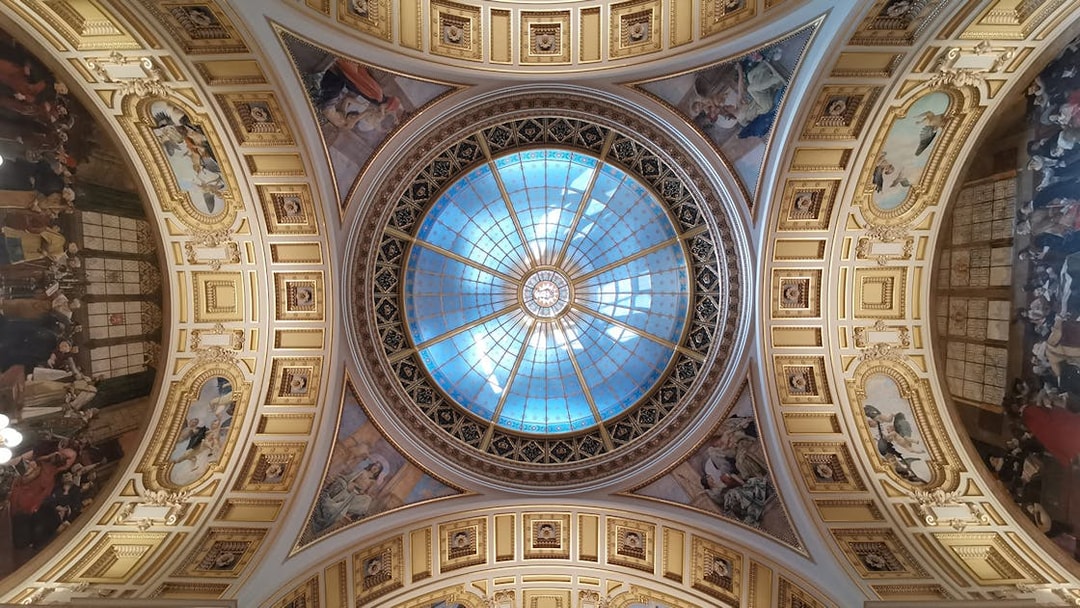 Ceiling of Prague's National Museum with ornate frescoes and a central glass dome.