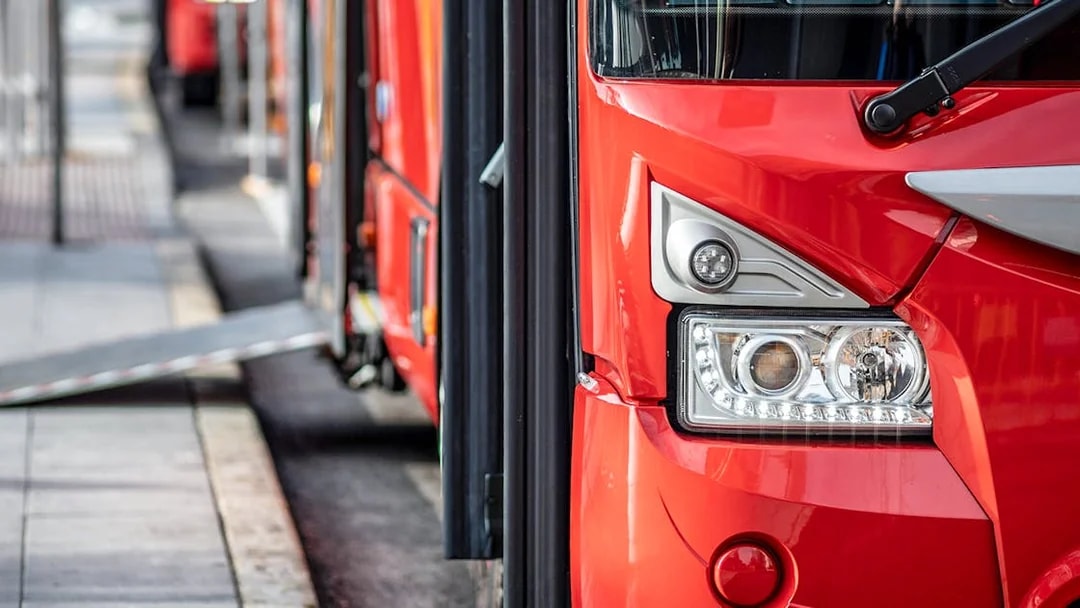 Red bus at Ibiza Airport terminal for one-way transfer to Ibiza.