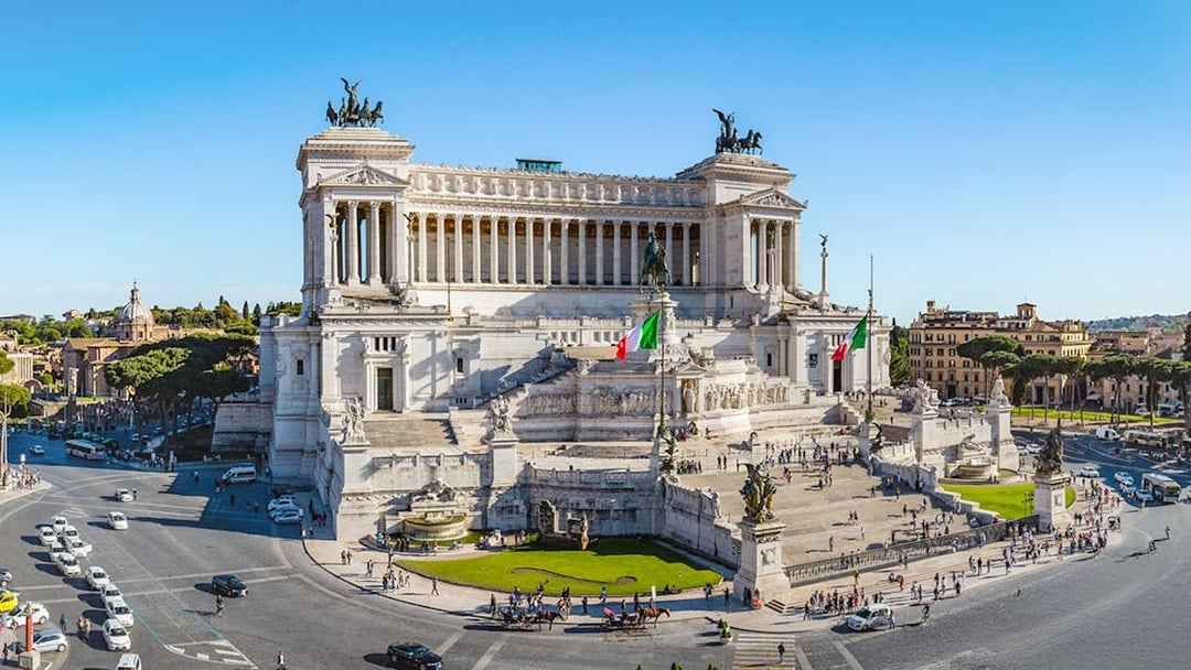 Altare della Patria in Rome with Italian flags and surrounding cityscape.