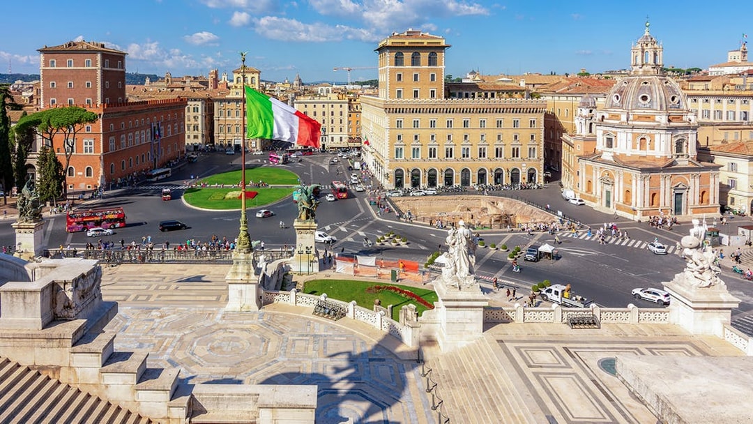 Venice square view from Altare della Patria, Rome, with Italian flag and historic buildings.