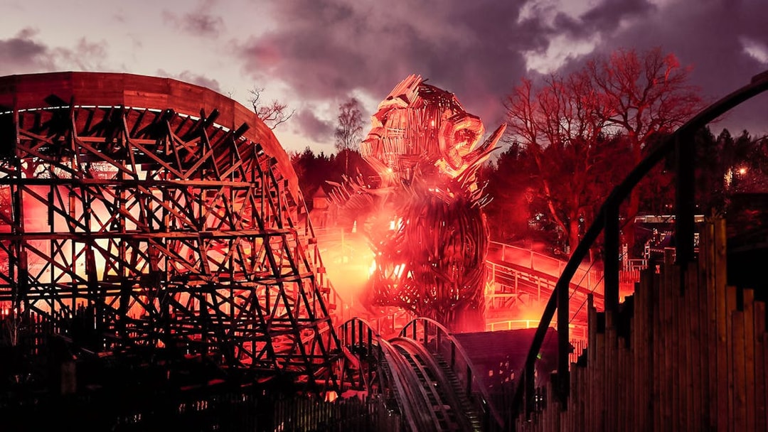 Wicker Man ride at Alton Towers with fiery wooden structure at dusk.