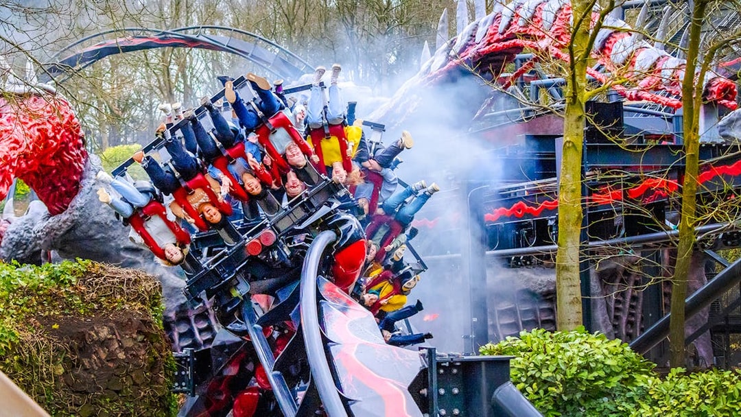 Riders on Nemesis Reborn roller coaster at Alton Towers, upside down on a loop.