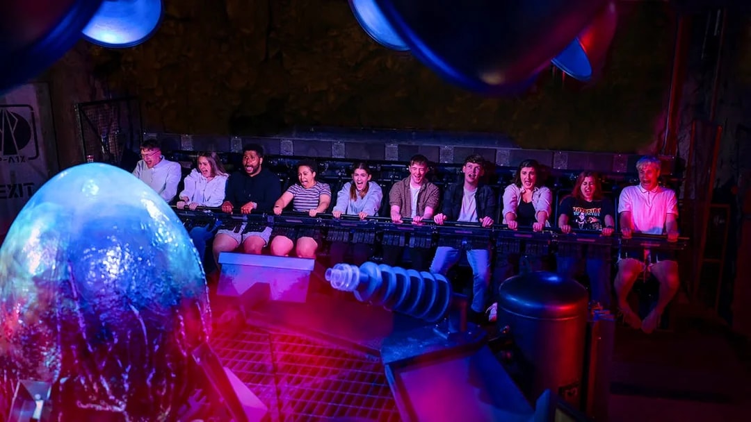 Visitors experiencing Nemesis Sub-Terra ride at Alton Towers with glowing alien egg.
