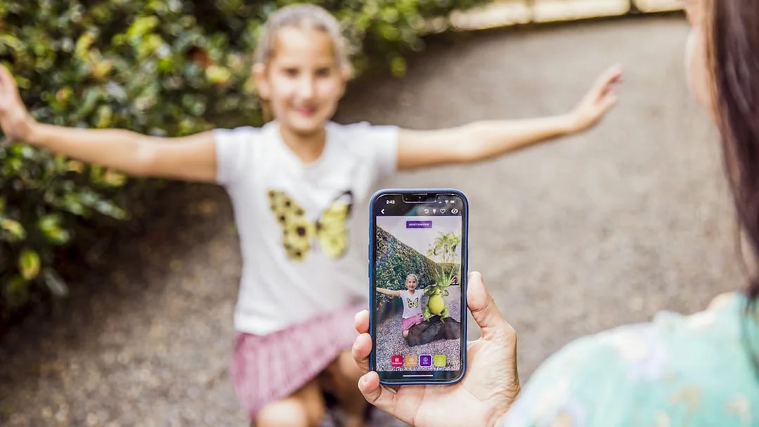 Child posing with arms outstretched at Amaze World, captured on a smartphone.