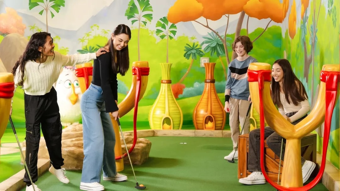 Group playing mini golf at Angry Birds Mini Golf, American Dream, with colorful slingshot obstacles.