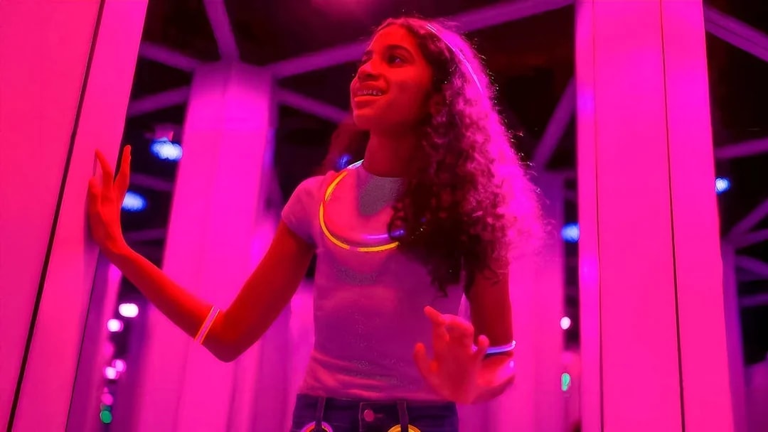 Kids exploring Mirror Maze at American Dream, surrounded by glowing lights.