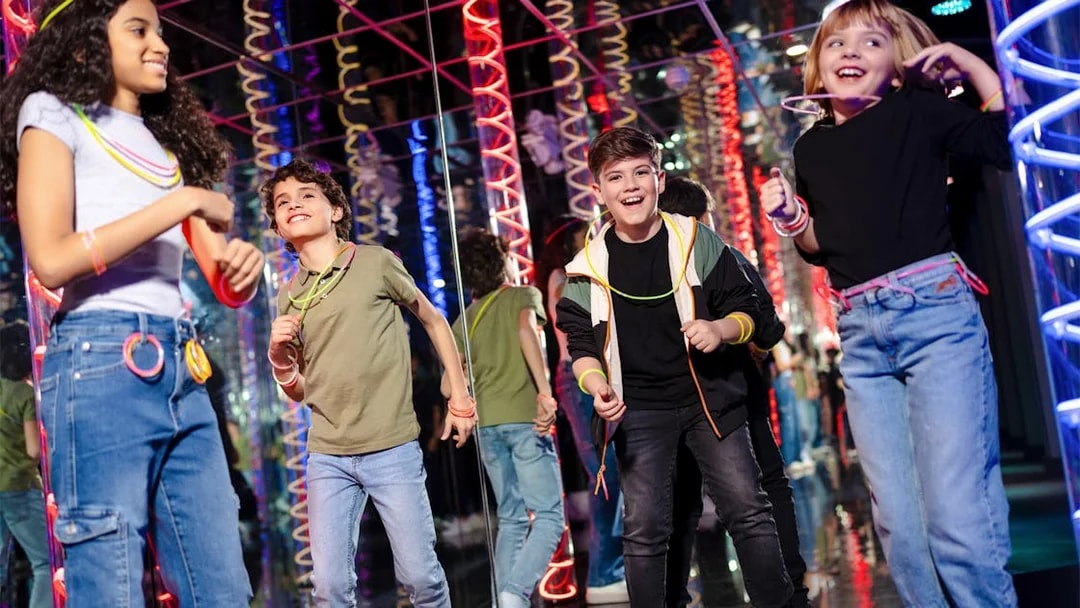 Children enjoying Nickelodeon Universe at American Dream with colorful lights.