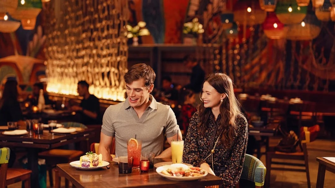 Guests dining at a vibrant restaurant in American Dream, enjoying drinks and meals.