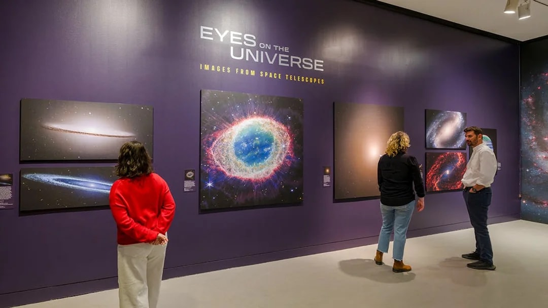 Visitors viewing space images at the Eyes on the Universe exhibit, American Museum of Natural History.