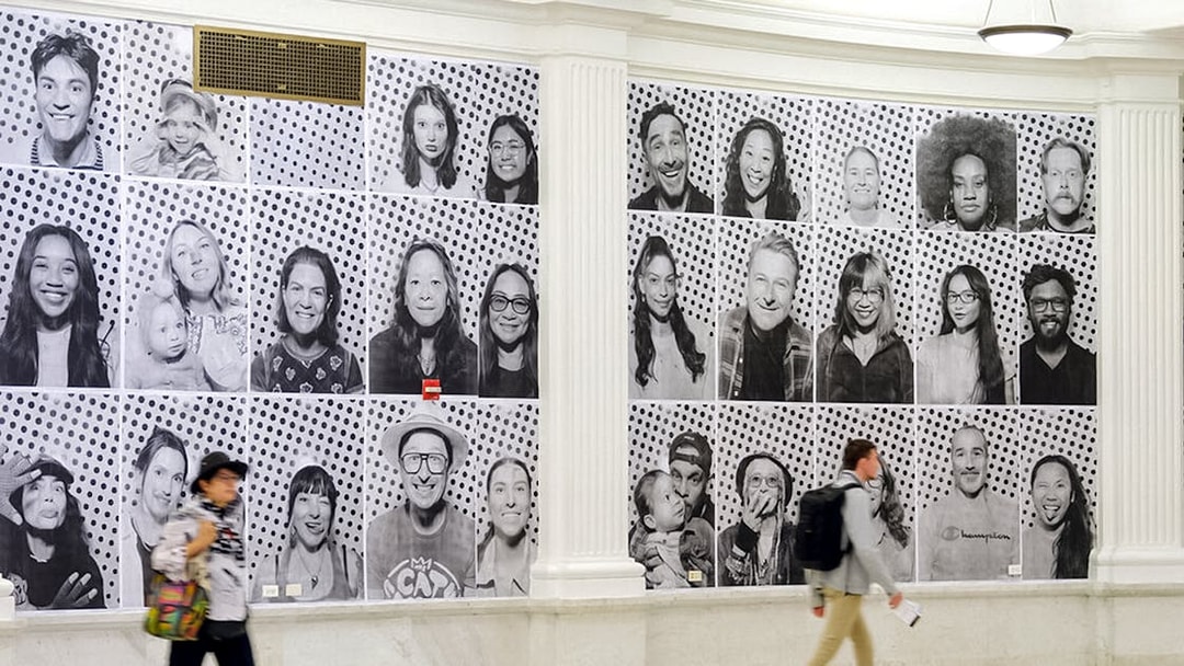 Black and white portraits displayed on a wall, part of "Climate and Health Dreams We Carry" exhibit.