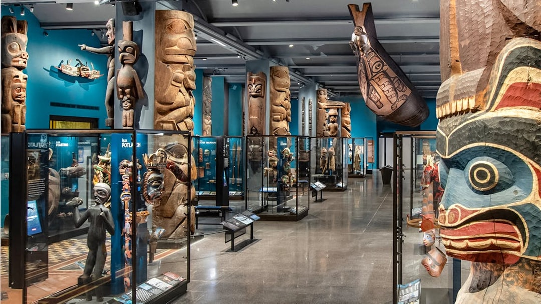 Native American totem poles and artifacts in the American Museum of Natural History exhibit hall.