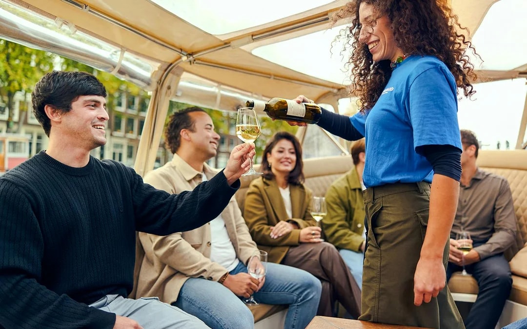 Guests enjoying wine on an evening candlelight cruise.