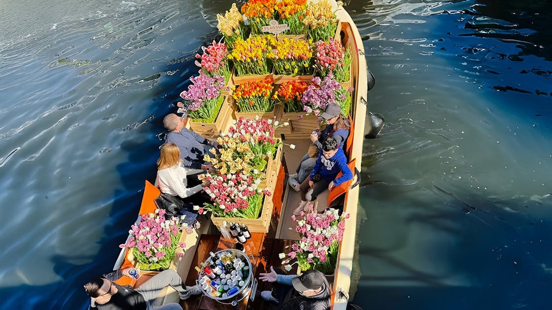 Guests enjoying a tulip-filled boat tour on Amsterdam's canals.