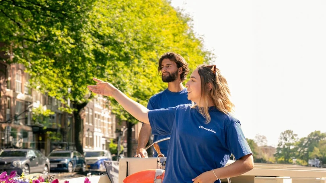 Guides on Amsterdam canal cruise boat with flowers and life preserver