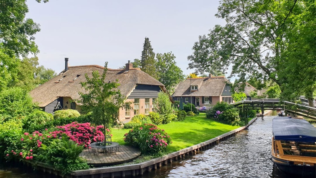 Thatched cottages and canal in Giethoorn, Netherlands, seen on a day trip from Amsterdam by bus and boat.