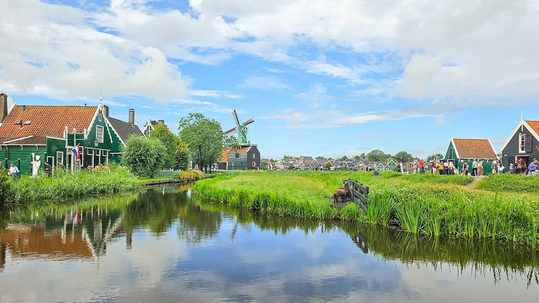 Giethoorn canal with traditional houses and windmill in Zaanse Schans day tour.