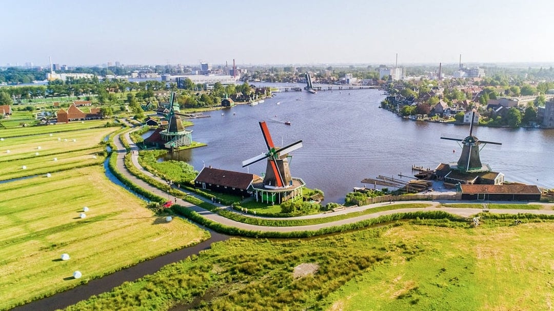 Aerial view of Zaanse Schans windmills by the river near Amsterdam.