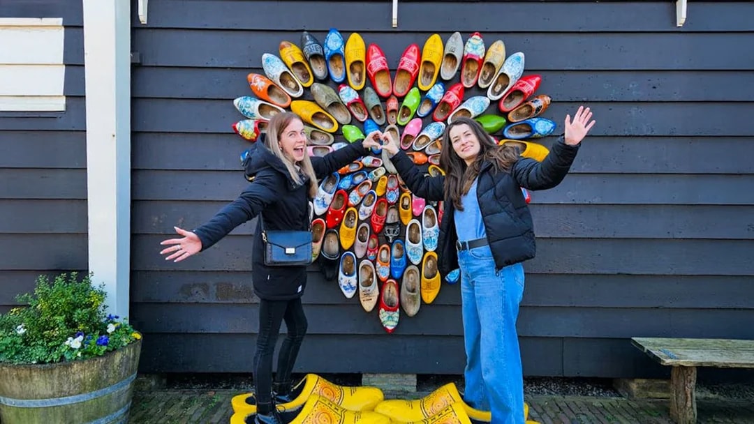 Guests posing with colorful clogs at Zaanse Schans, Netherlands.