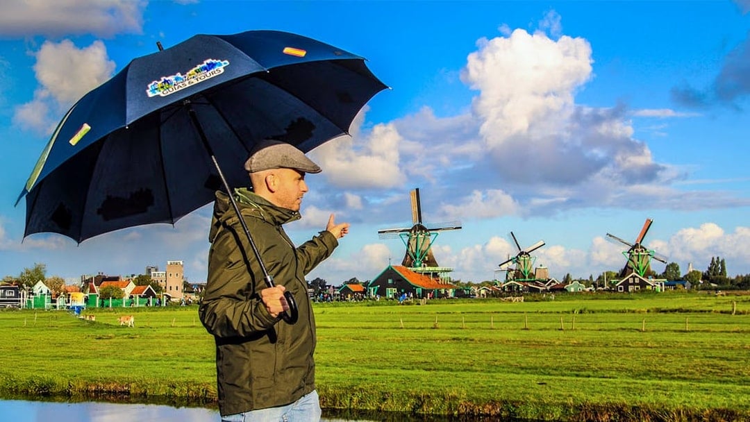 Person pointing at windmills during a guided tour of Zaanse Schans.