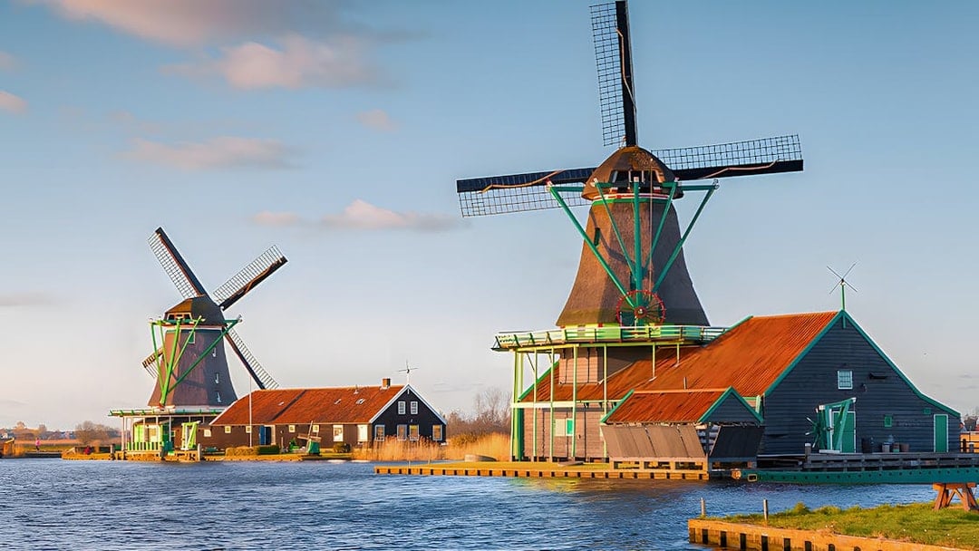 Windmills at Zaanse Schans by the water in the Netherlands.