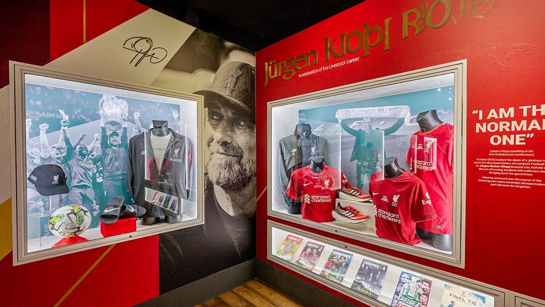 Liverpool FC memorabilia display featuring jerseys and trophies at Anfield Stadium Museum.