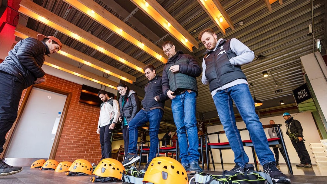 Visitors preparing for Anfield abseil with helmets and harnesses at Liverpool FC Stadium.