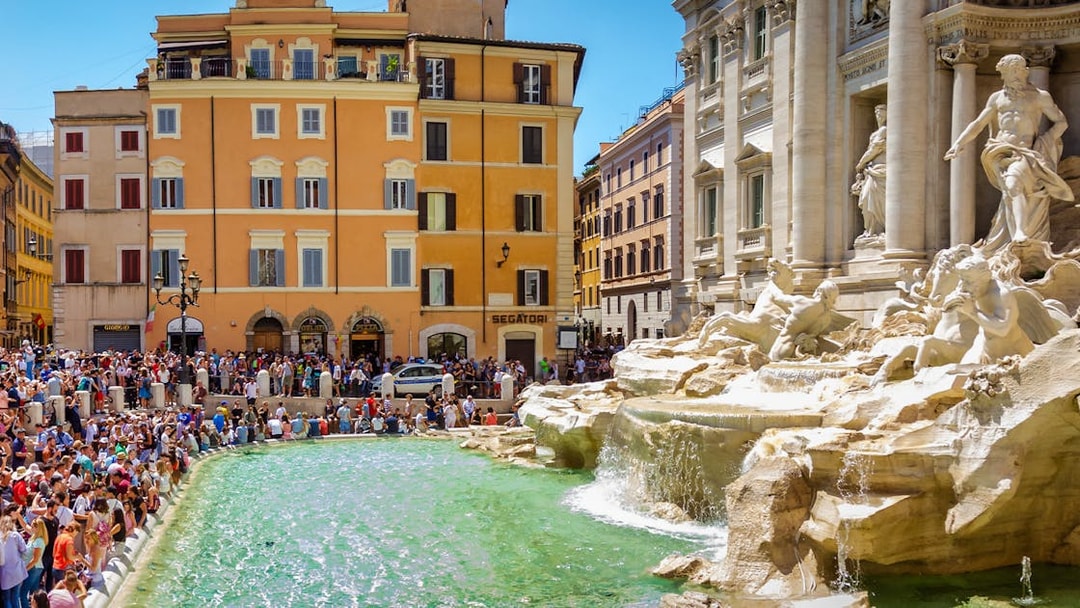 Trevi Fountain in Rome with a crowd of tourists, part of the Official Angels & Demons Tour.