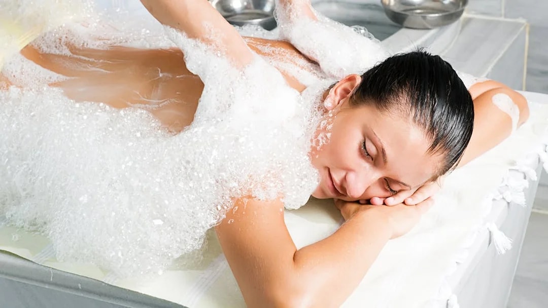 Person receiving a foam massage in a traditional Turkish bath in Antalya.