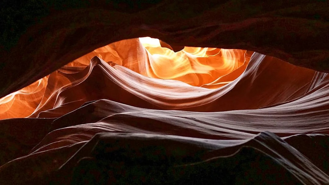 Upper Antelope Canyon's swirling sandstone formations illuminated by sunlight.