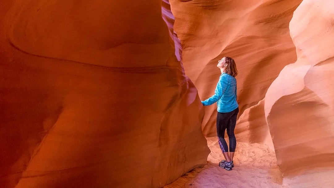 Young woman exploring the sandstone formations of Antelope Canyon, Arizona.
