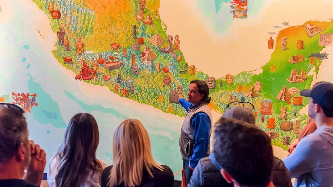 Visitors listening to a guide at the National Museum of Anthropology, Mexico City.