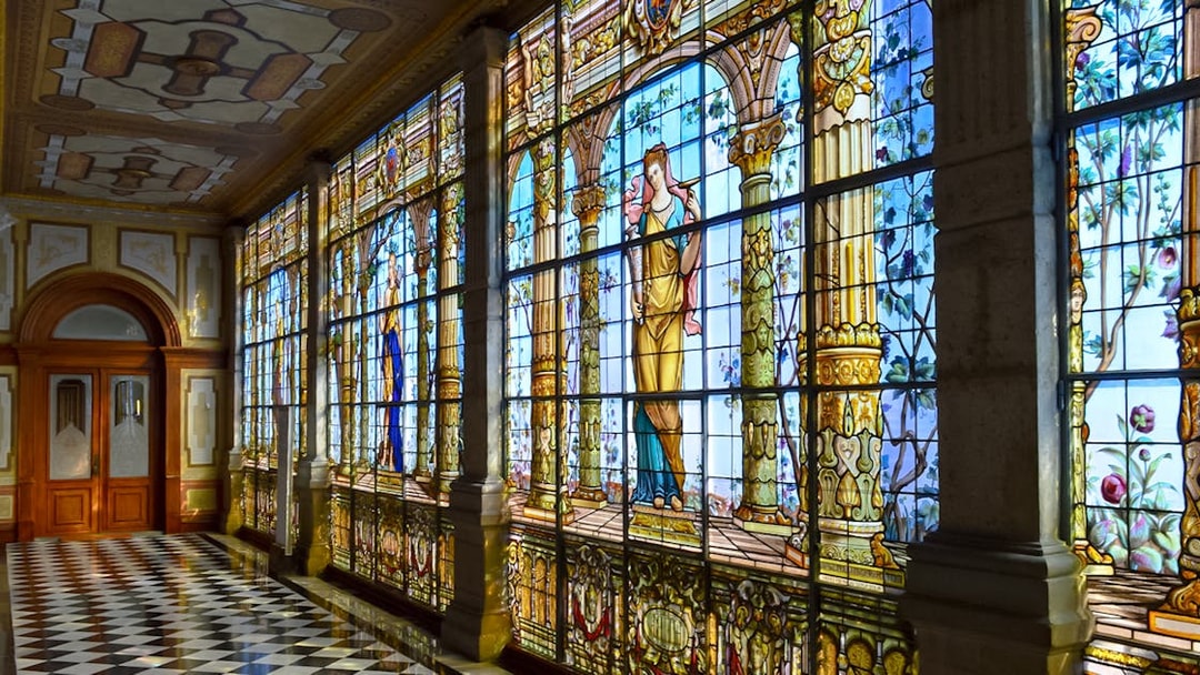 Stained glass windows inside Chapultepec Castle, Mexico City, depicting historical figures.