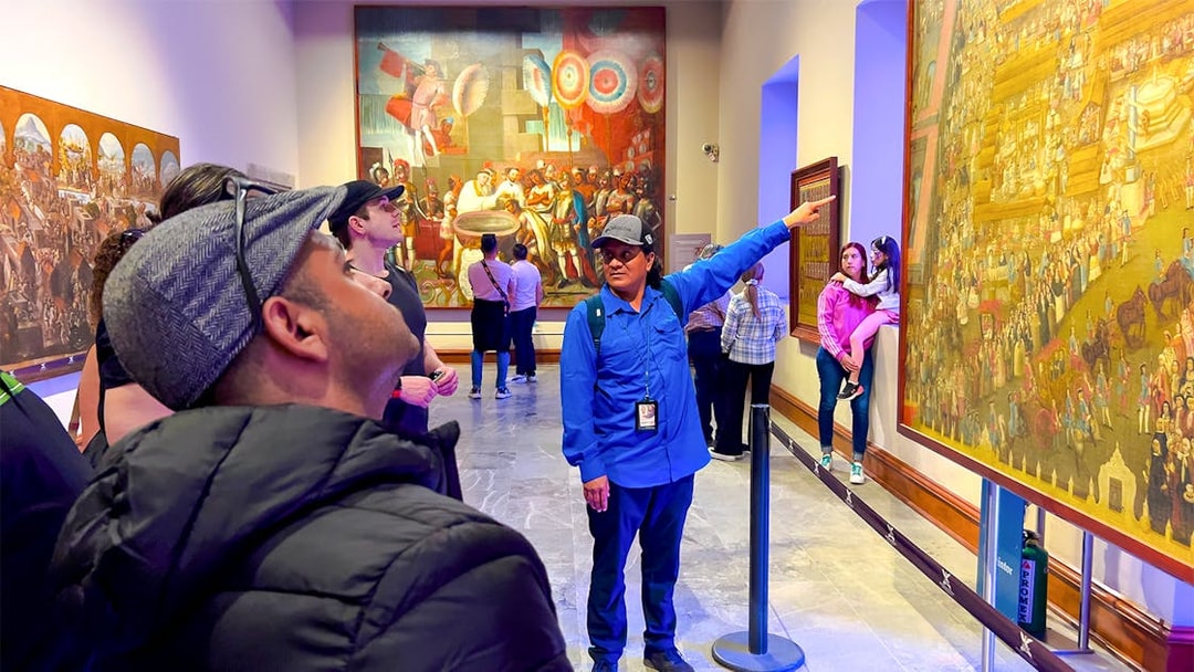 Tour guide explaining mural at anthropology museum, Mexico.
