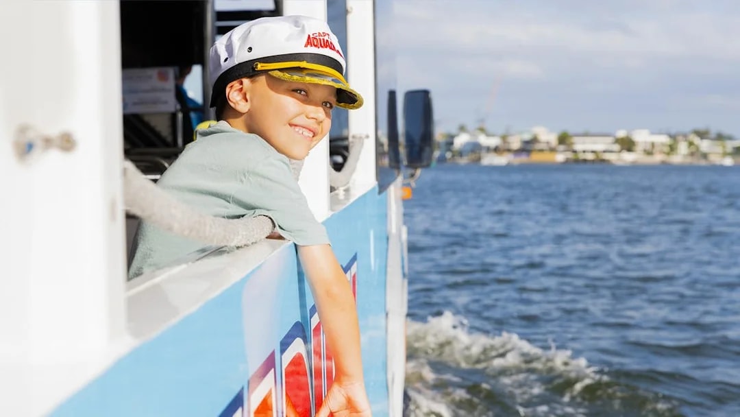 Child enjoying Aquaduck city tour and river cruise, leaning out of the boat.