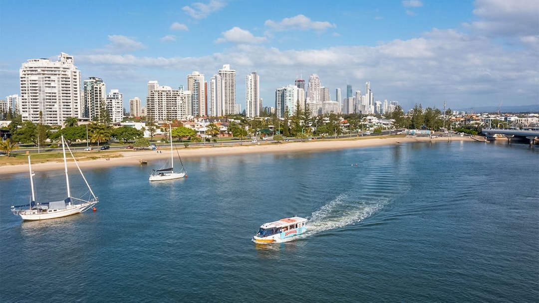 Aquaduck tour boat cruising along Sunshine Coast with city skyline in the background.