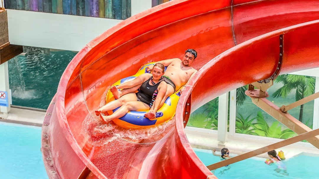 Tourists enjoying a water slide at Aqualibi Park, Belgium.