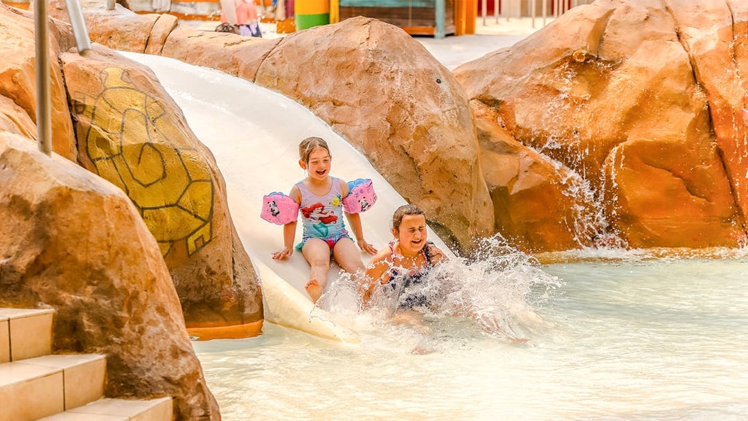 Children enjoying a water slide at Aqualibi Park, Belgium.