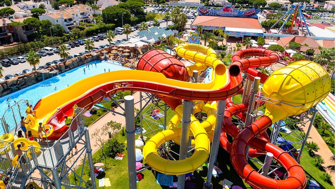 Colorful water slides at Aquashow Park, Portugal, with visitors enjoying the attractions.