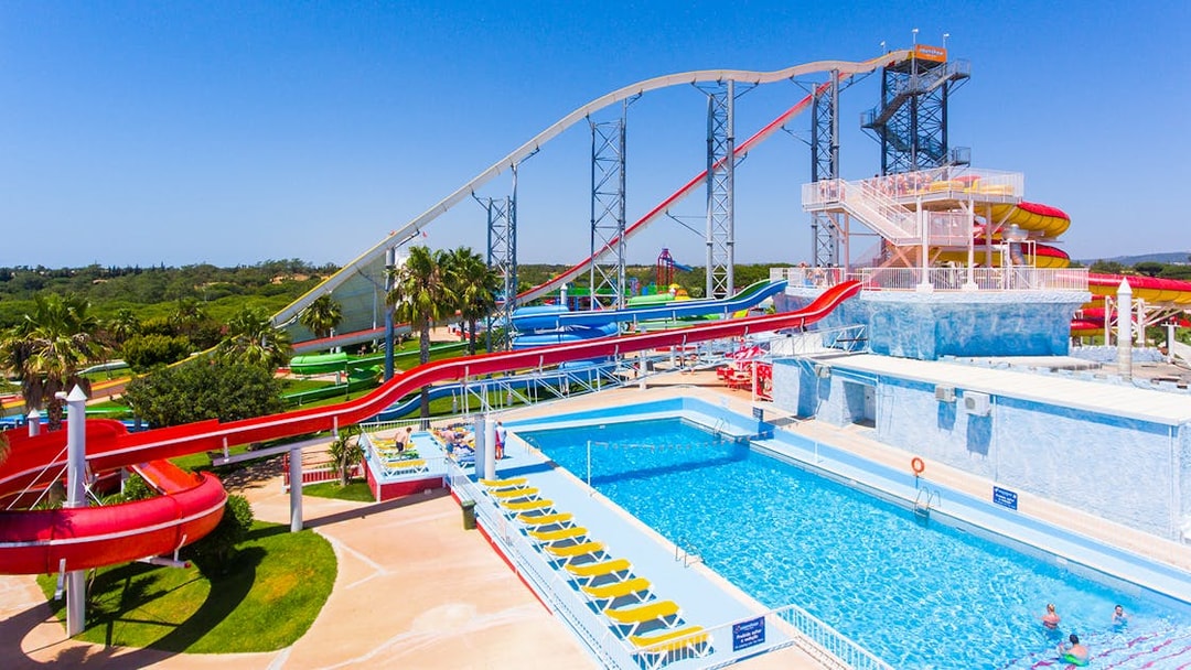 Water slides and pool at Aquashow Park, Portugal, with visitors enjoying the attractions.
