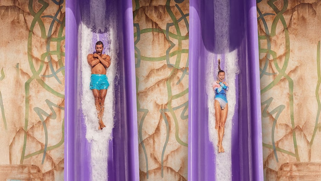 Two people sliding down the Blackout adventure ride at Atlantis, The Palm, Dubai.
