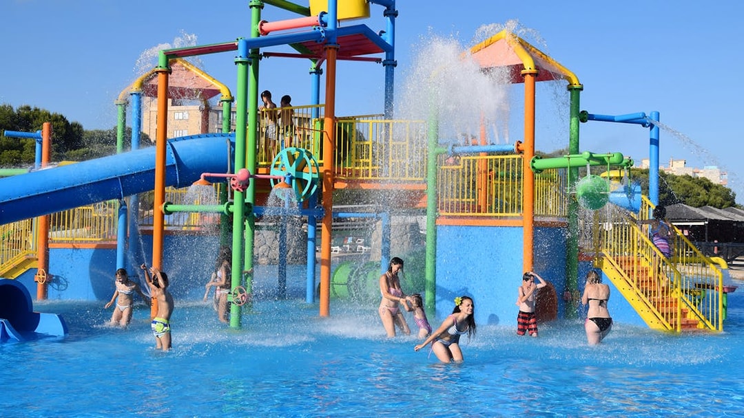 Children playing in water park at Aquopolis Costa Daurada with colorful slides and splash features.