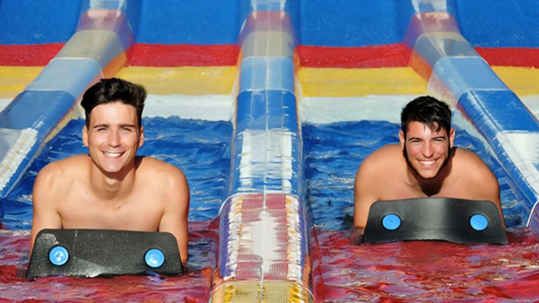 Two people enjoying a water slide at Aquopolis Torrevieja.